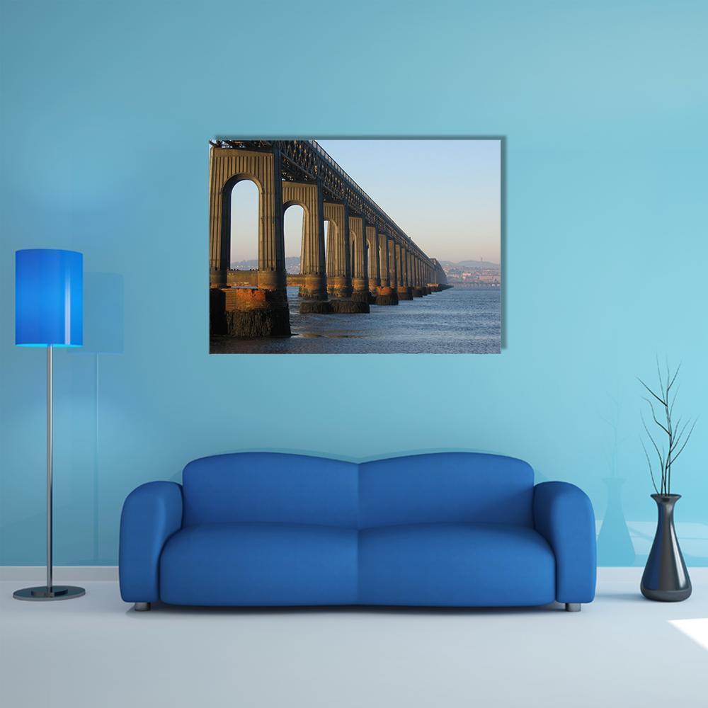 Railway Bridge with Arched Piers and Calm Water Canvas Wall Art in gray, brown and blue, single panel hung on a wall