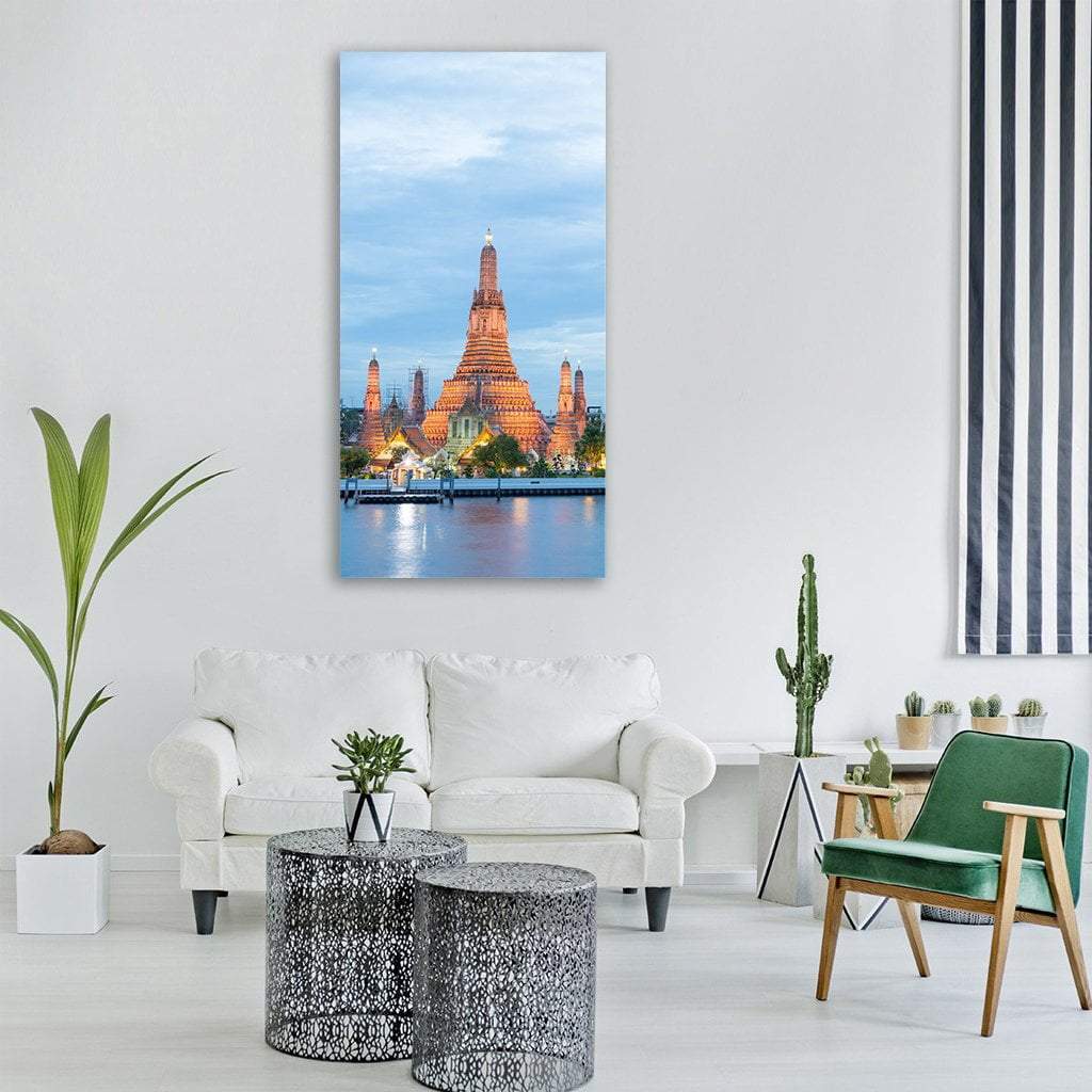 Wat Arun Temple at Dusk Vertical Canvas Wall Art in gold, orange and blue, single vertical panel hung on a wall