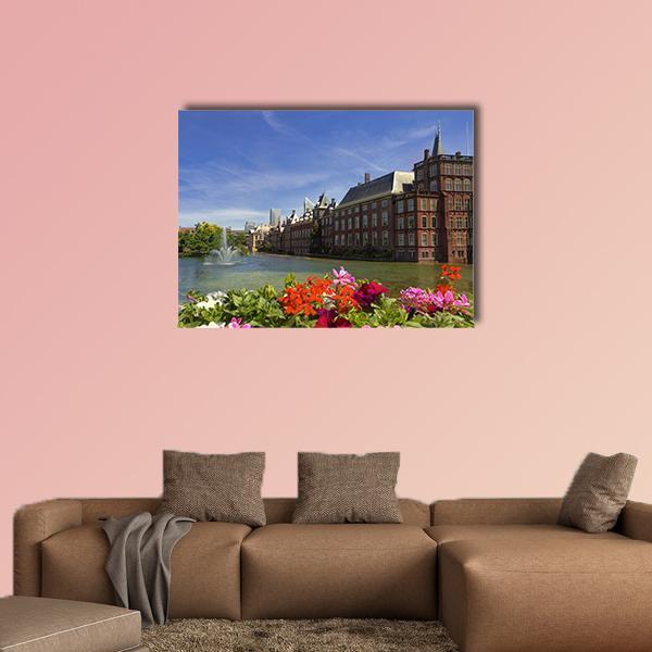 Dutch Parliament Buildings with Fountain and Flowers Canvas Wall Art in brown, green and blue, single panel hung on a wall