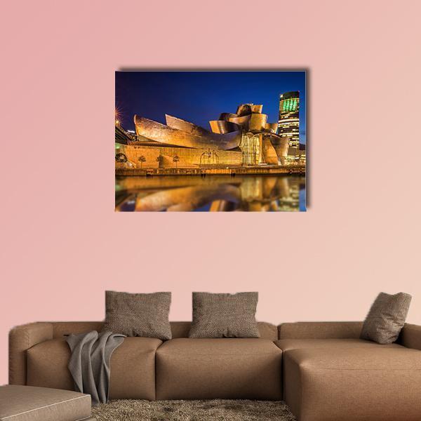 Guggenheim Museum Bilbao Night Reflection Canvas Wall Art in gold, yellow and blue, single panel hung on a wall