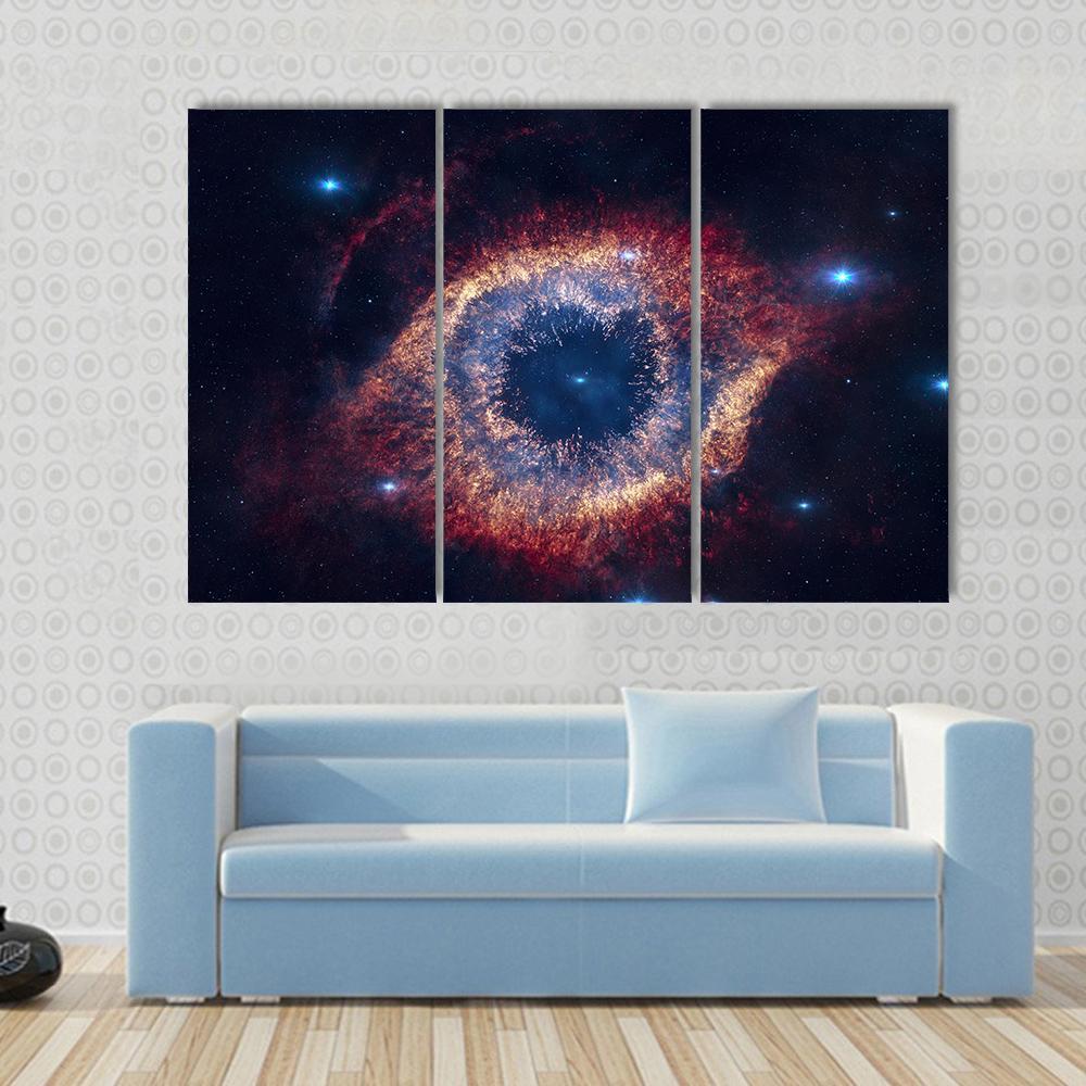 The Helix Nebula Eye of God Canvas Wall Art in black, red and blue, 3 panel horizontal set hung on a wall