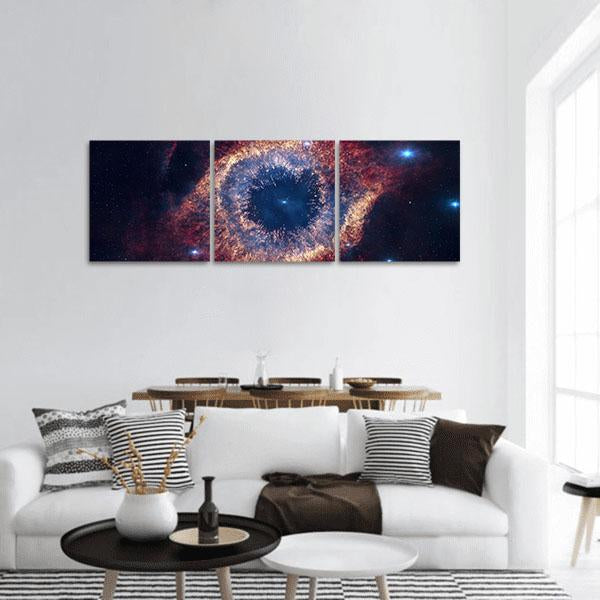 Helix Nebula Cosmic Eye Panoramic Canvas Wall Art in black, orange and blue, hung on a wall