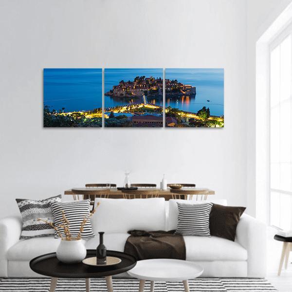 Sveti Stefan Causeway at Dusk Panoramic Canvas Wall Art in orange, yellow and blue, hung on a wall