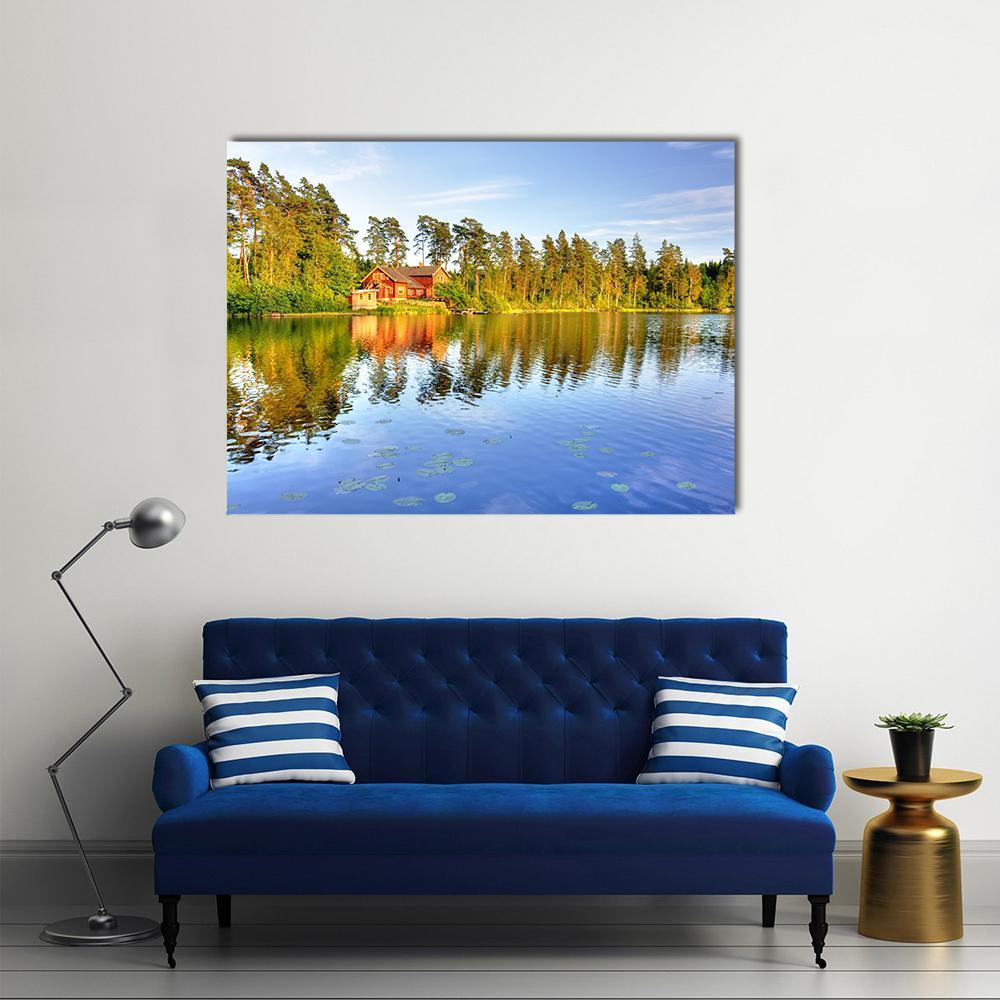 Red Cabin by the Lake Canvas Wall Art in red, green and blue, single panel hung on a wall