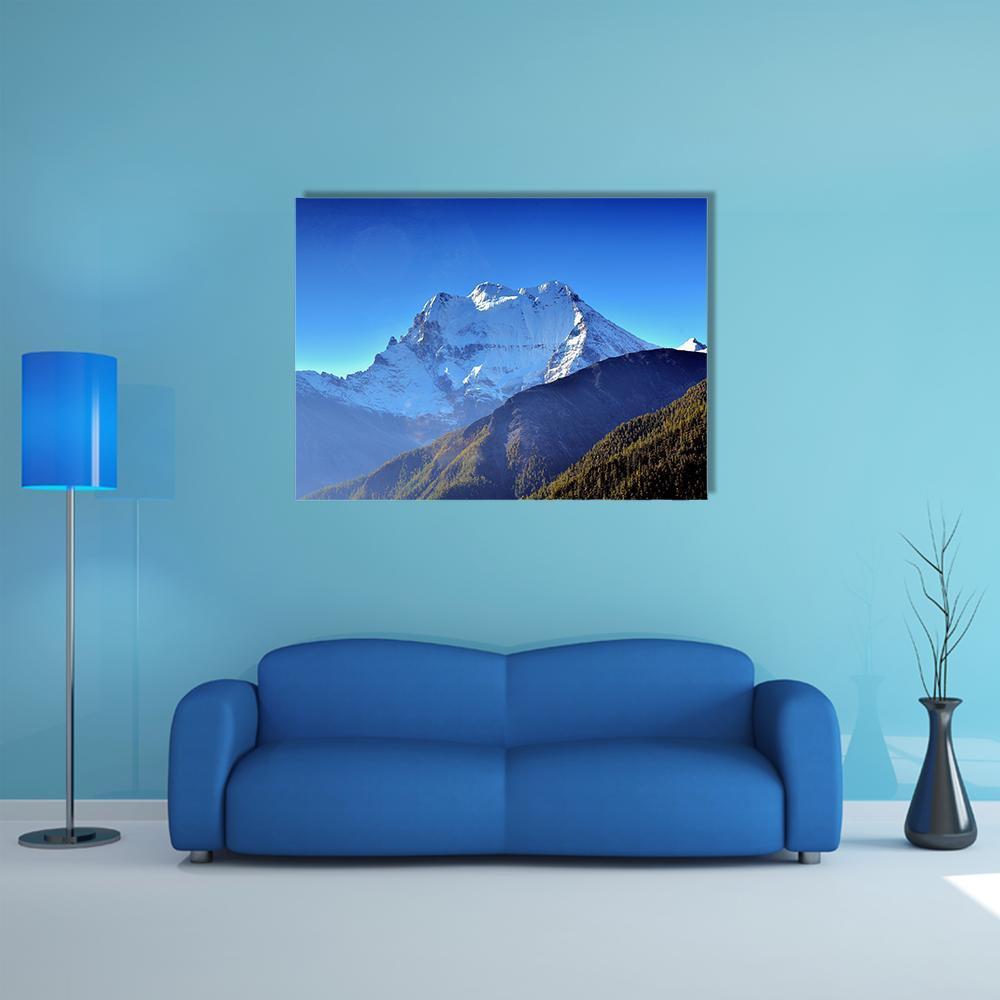 Sunlit Snow-capped Mountain Canvas Wall Art in white and blue, single panel hung on a wall