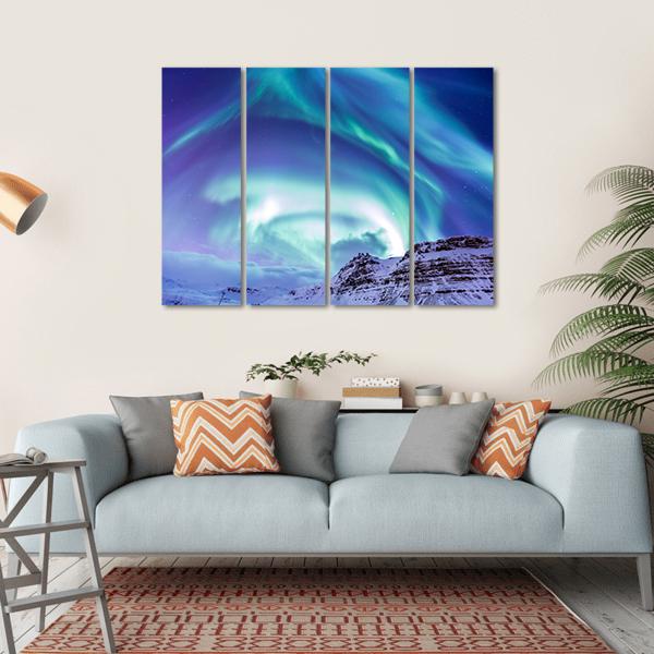 Aurora Over Kirkjufell Canvas Wall Art in green, blue and purple, hung on a wall