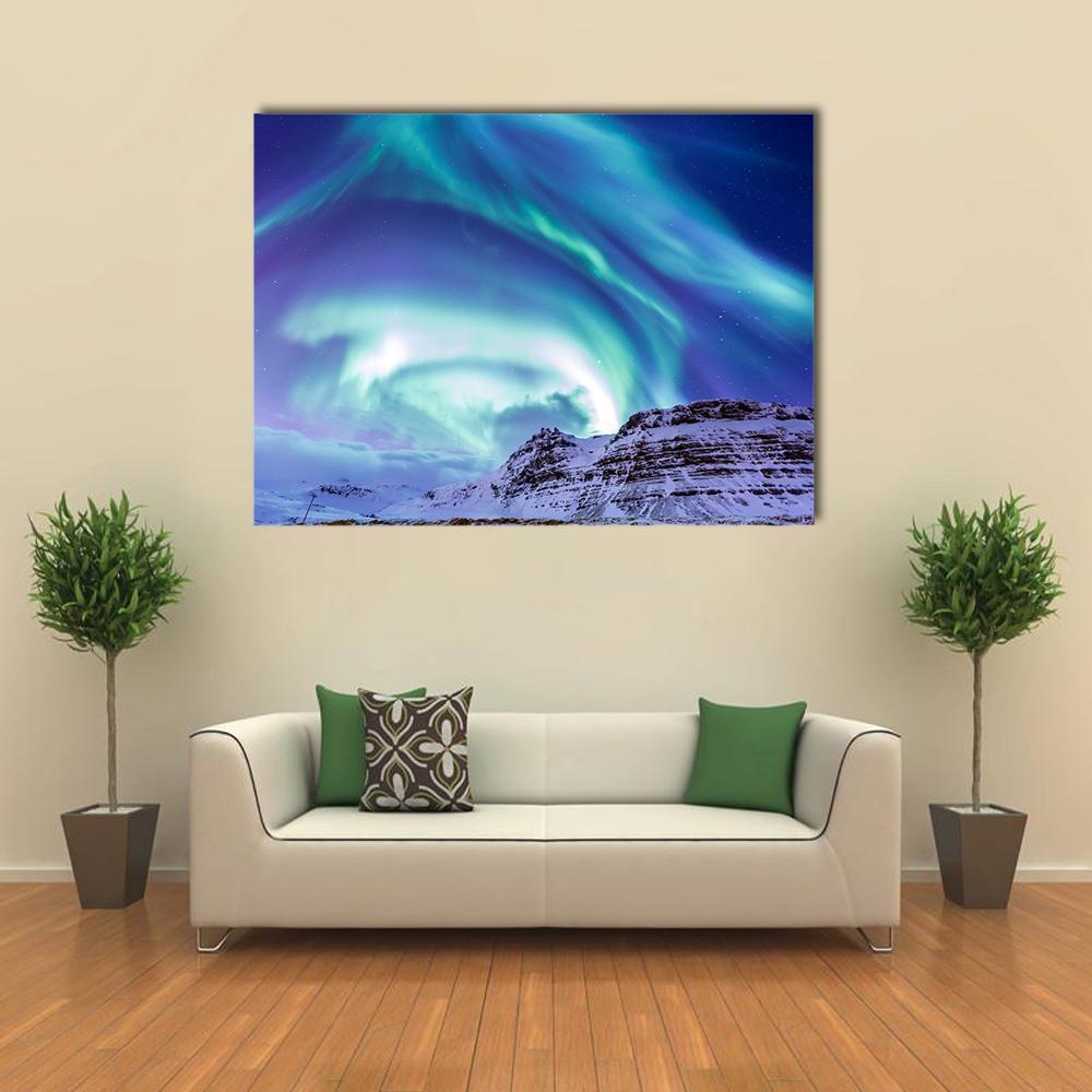 Aurora Over Kirkjufell Canvas Wall Art in green, blue and purple, single panel hung on a wall