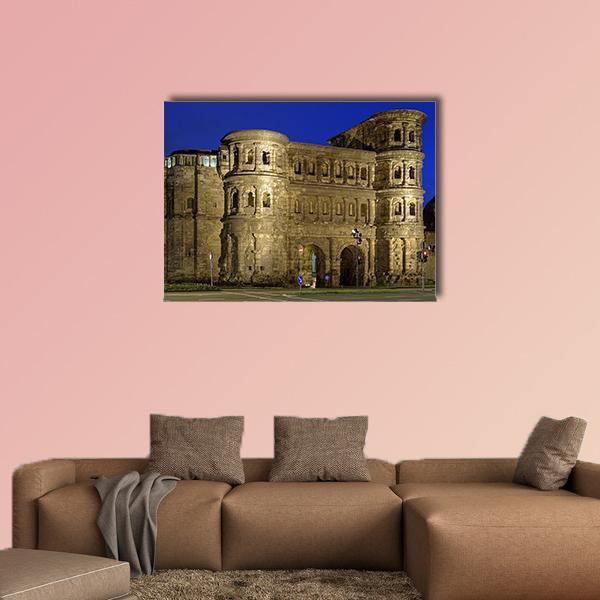 Porta Nigra at Night Canvas Wall Art in gray, brown and blue, single panel hung on a wall