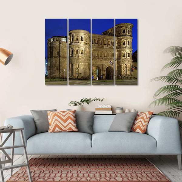 Porta Nigra at Night Canvas Wall Art in gray, brown and blue, hung on a wall