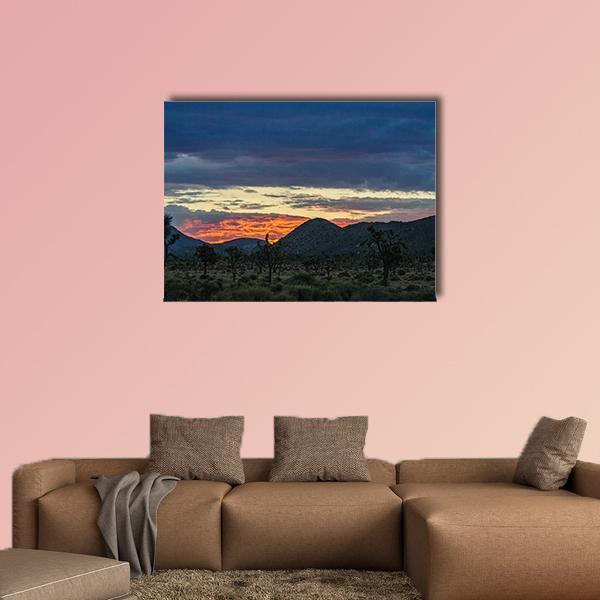 Joshua Trees at Sunset Over Mountains Canvas Wall Art in black, orange and blue, single panel hung on a wall