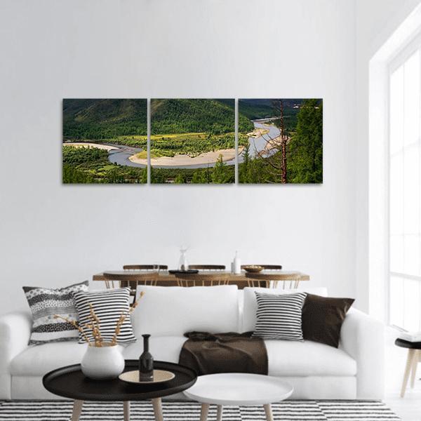 Meandering River Through Forested Mountains Panoramic Canvas Wall Art in brown, green and blue, hung on a wall