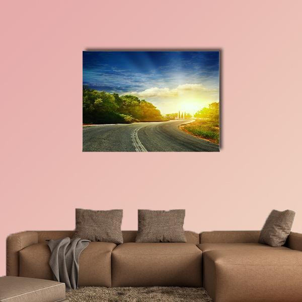 Curving Mountain Road with Sunbeams Canvas Wall Art in yellow, green and blue, single panel hung on a wall