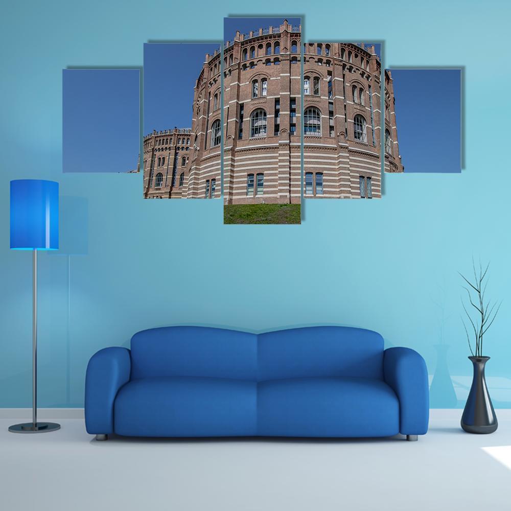 Vienna Gasometer Brick Facade Canvas Wall Art in brown, red and blue, 5 panel Star layout hung on a wall
