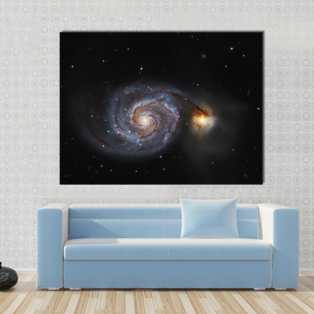 The Whirlpool Galaxy Canvas Wall Art in black and blue, single panel hung on a wall