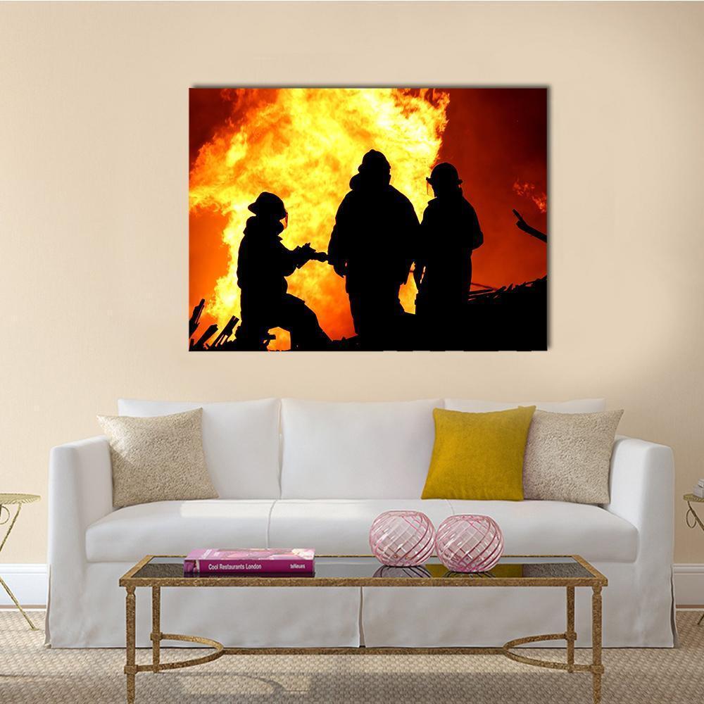 Three Firefighters Fighting a Fire Canvas Wall Art in black, orange and yellow, single panel hung on a wall