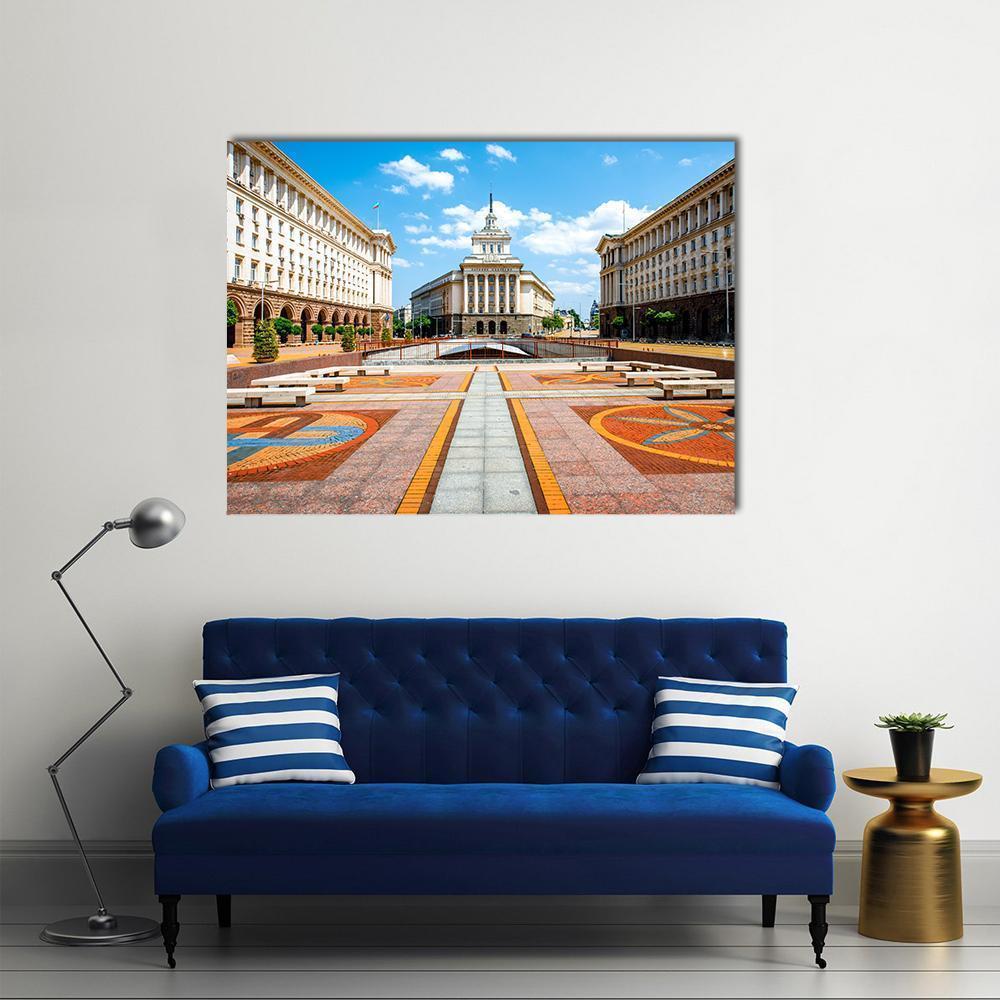 Three Socialist Classicism Buildings Canvas Wall Art in beige, orange and blue, single panel hung on a wall