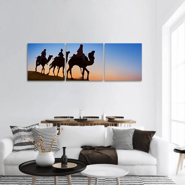 Three Wise Men at Sunset Panoramic Canvas Wall Art in black, orange and blue, hung on a wall