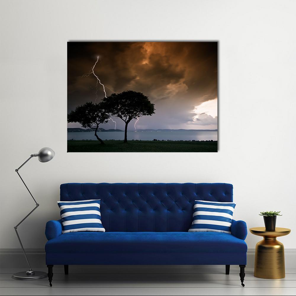 Lightning Striking Trees at Night Canvas Wall Art in black, brown and blue, single panel hung on a wall