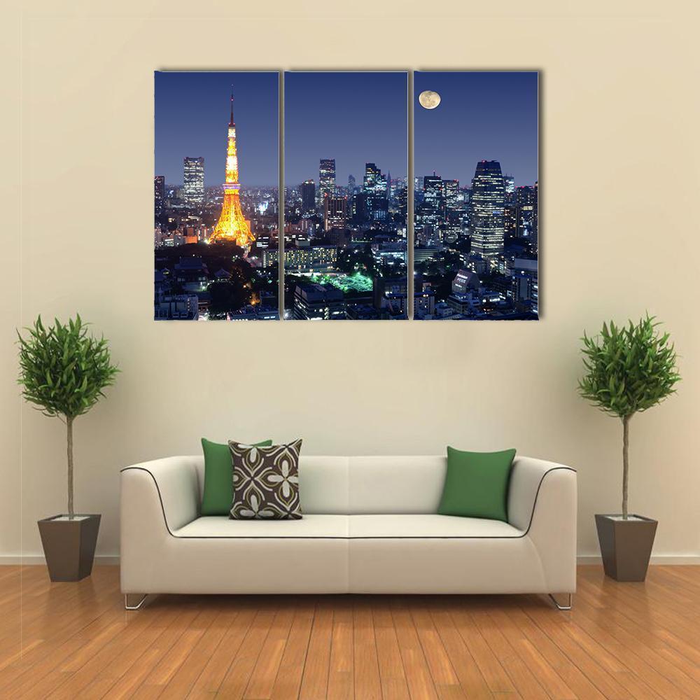 Tokyo Tower Under a Full Moon Canvas Wall Art in black and blue, 3 panel horizontal set hung on a wall