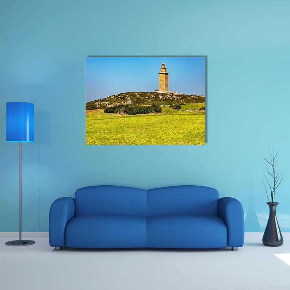 Tower of Hercules on Flowered Hill Canvas Wall Art in yellow, green and blue, single panel hung on a wall