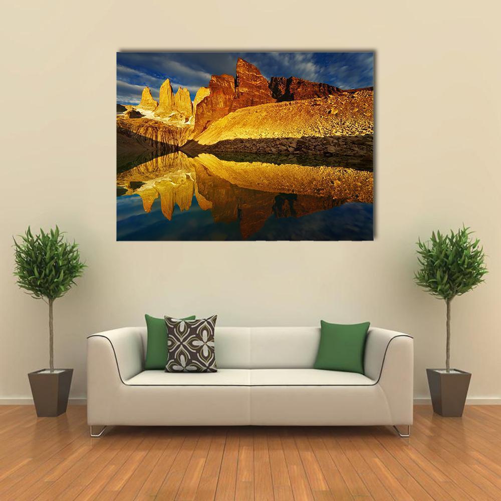 Sunrise Mountain Peaks with Lake Reflection Canvas Wall Art in orange, yellow and blue, single panel hung on a wall