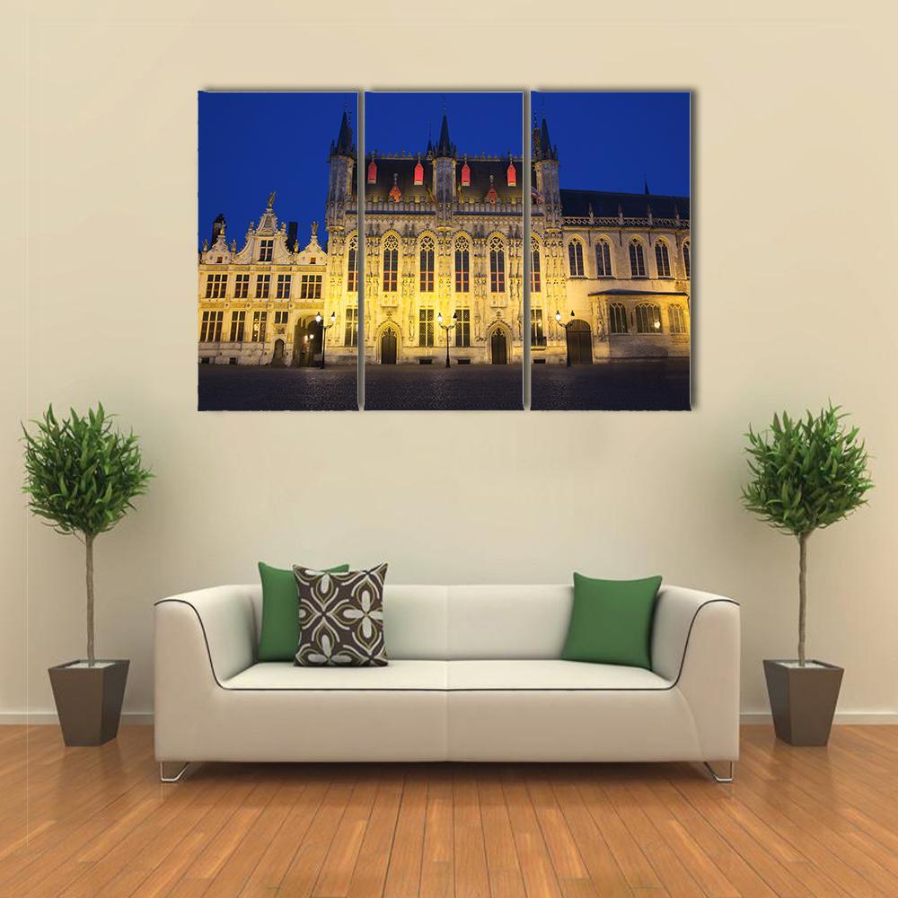 Town Hall and Burg Square at Night Canvas Wall Art in black, yellow and blue, 3 panel horizontal set hung on a wall