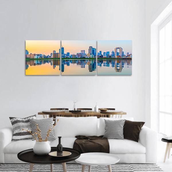 Osaka Skyline at Golden Hour Panoramic Canvas Wall Art in orange, yellow and blue, hung on a wall