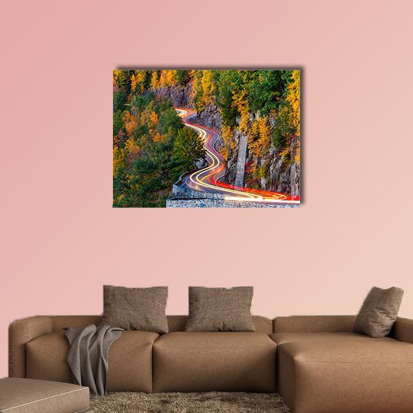 Traffic Light Trails on Winding Mountain Road Canvas Wall Art in red, orange and green, single panel hung on a wall