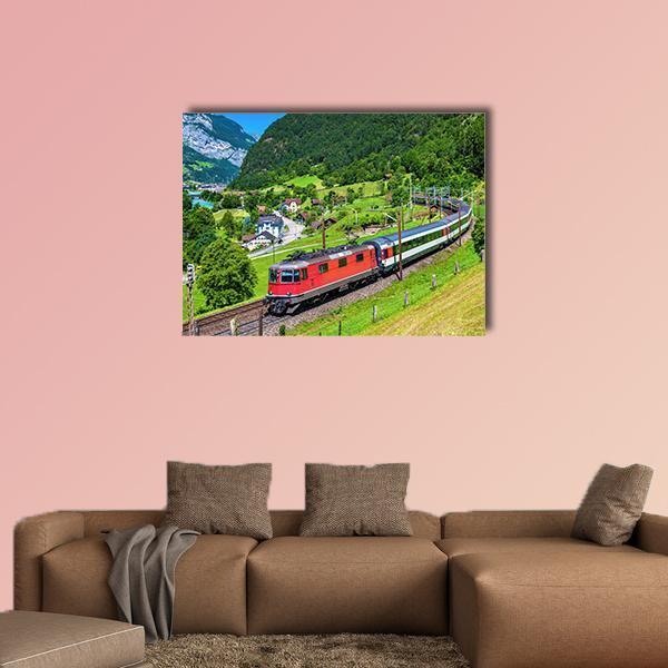Red Train on Curved Mountain Track Canvas Wall Art in red, green and blue, single panel hung on a wall