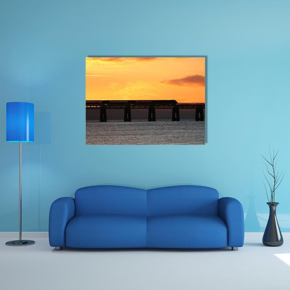 Train Crossing Tay Rail Bridge at Sunset Canvas Wall Art in black, orange and yellow, single panel hung on a wall