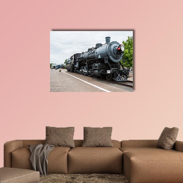 Vintage Steam Locomotive on Brick Platform Canvas Wall Art in black and gray, single panel hung on a wall