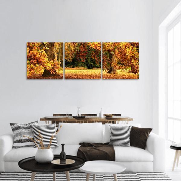 Tranquil Autumn Forest Panoramic Canvas Wall Art in brown, orange and yellow, hung on a wall
