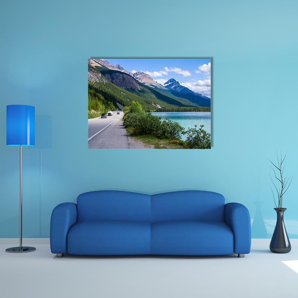 Travelers Along Mountain Lake Road Canvas Wall Art in gray, green and blue, single panel hung on a wall