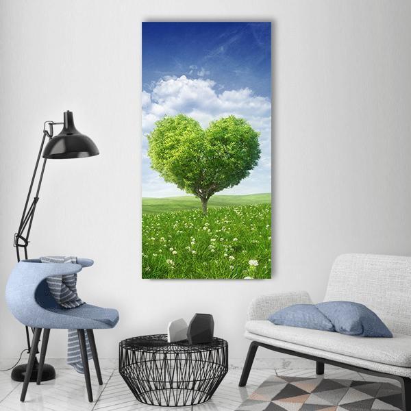 Heart-shaped Tree in Green Meadow Vertical Canvas Wall Art in white, green and blue, single vertical panel hung on a wall