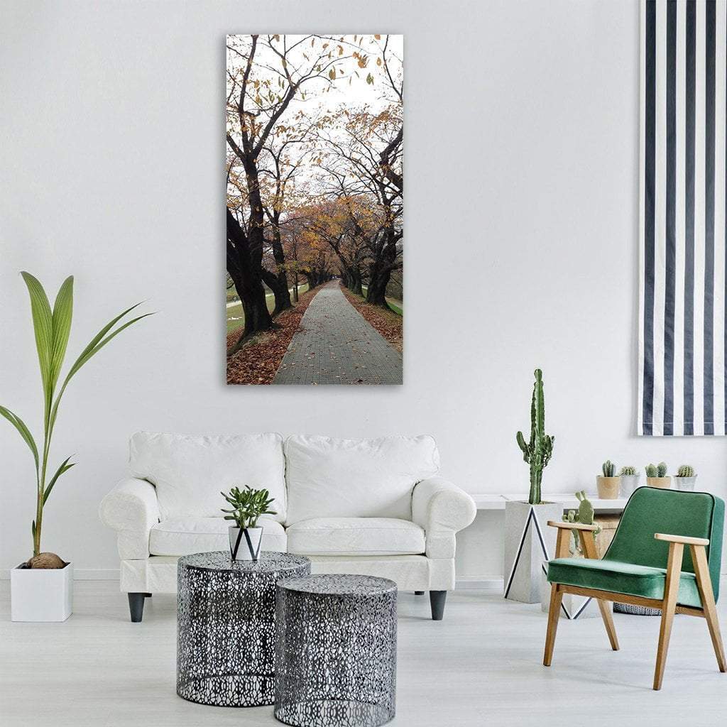 Tree-lined Avenue in Autumn Vertical Canvas Wall Art in gray, brown and orange, single vertical panel hung on a wall
