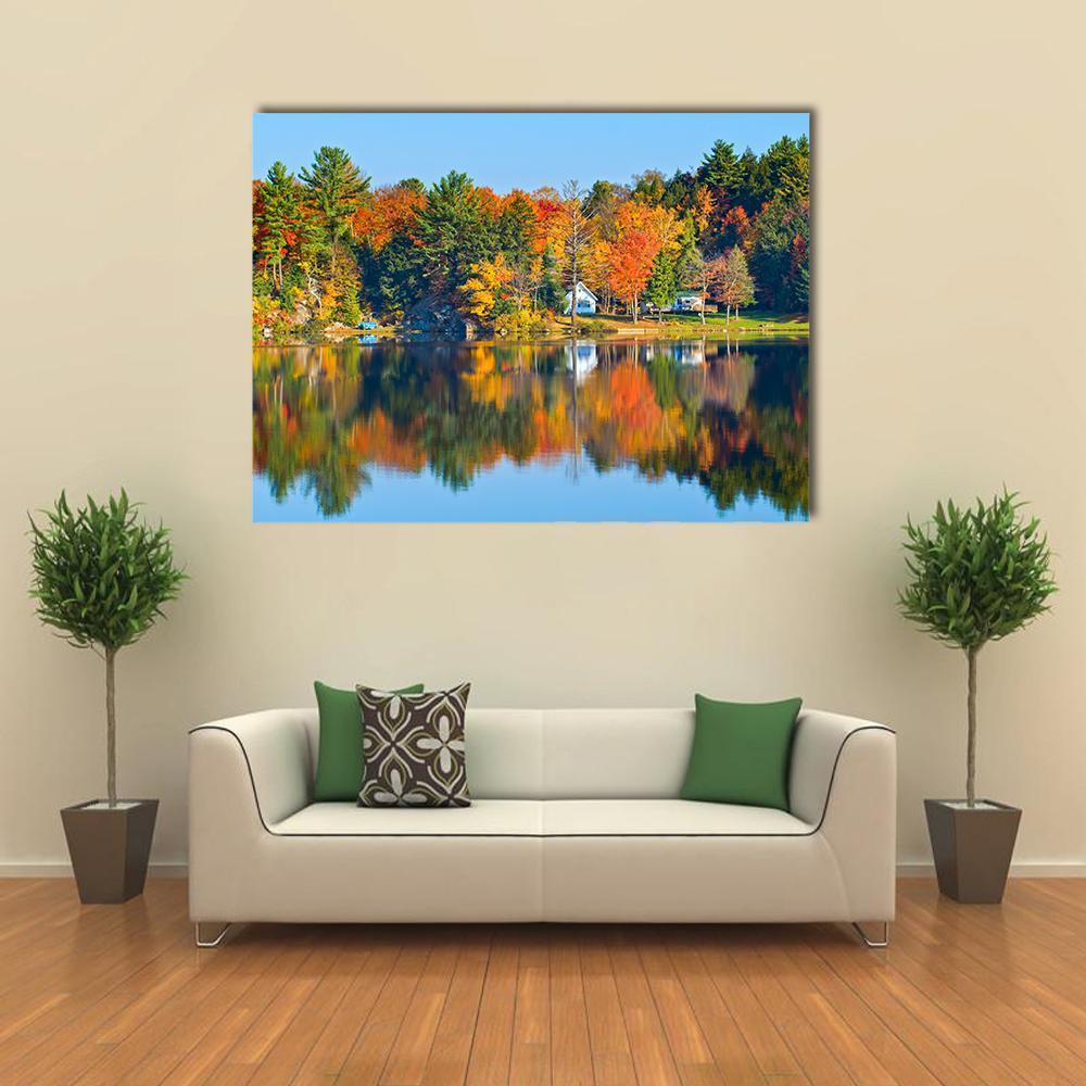 Trees Reflecting in a Calm Lake Canvas Wall Art in orange, green and blue, single panel hung on a wall