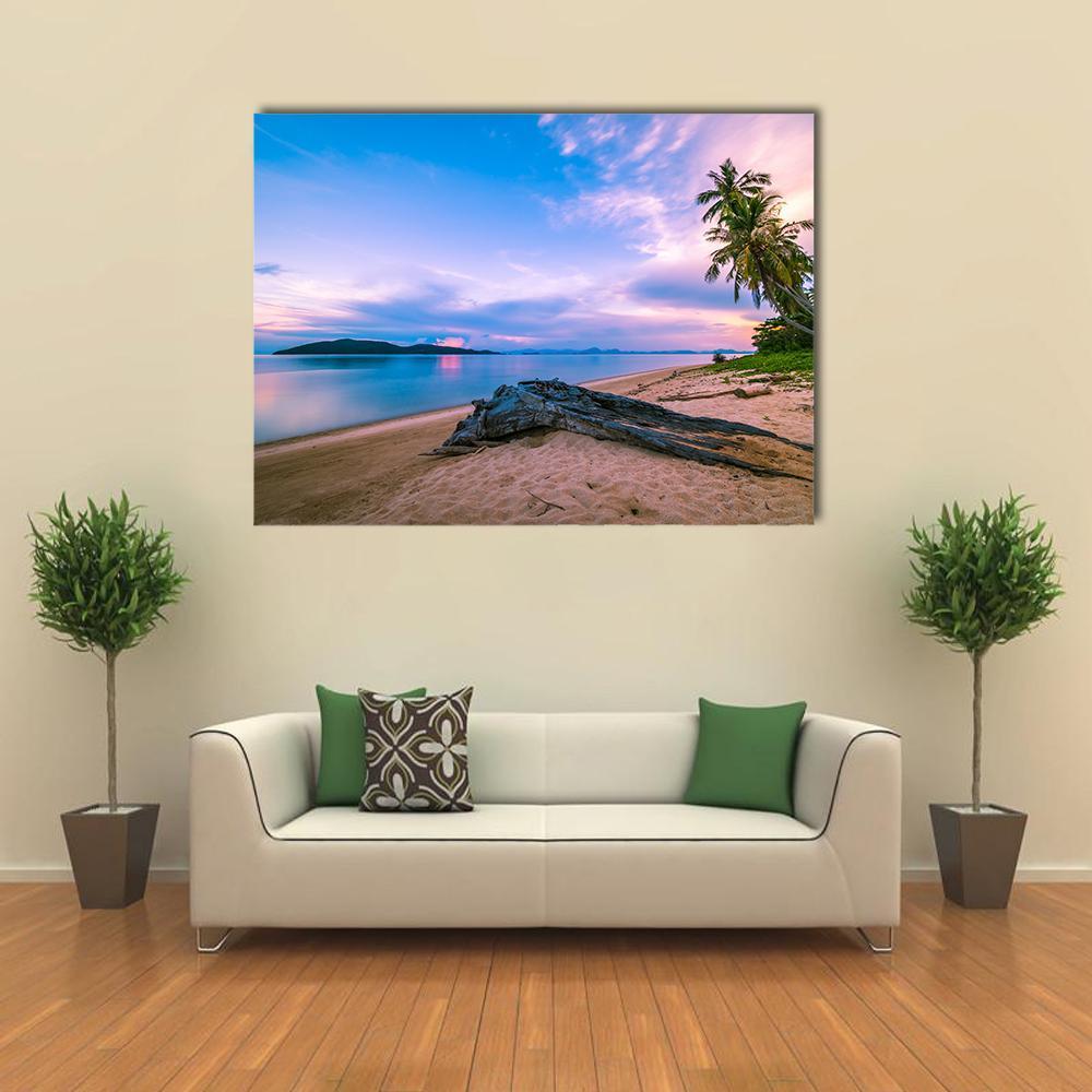 Tropical Beach with Driftwood at Sunset Canvas Wall Art in beige, blue and pink, single panel hung on a wall