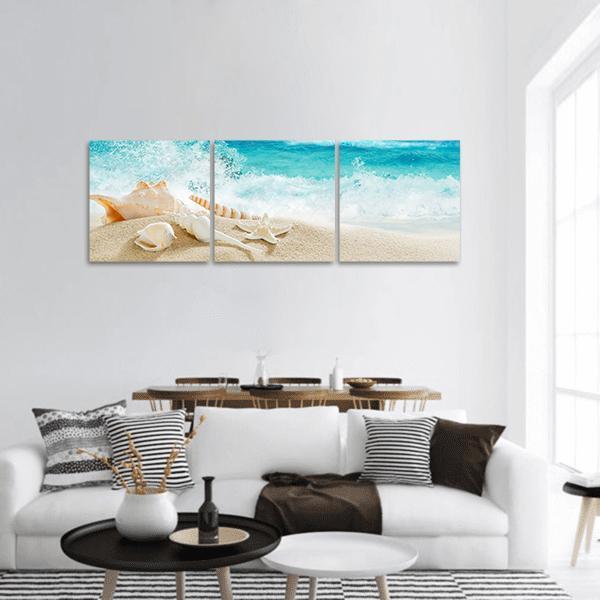Tropical Beach with Seashells and Splashing Waves Panoramic Canvas Wall Art in white, beige and blue, hung on a wall