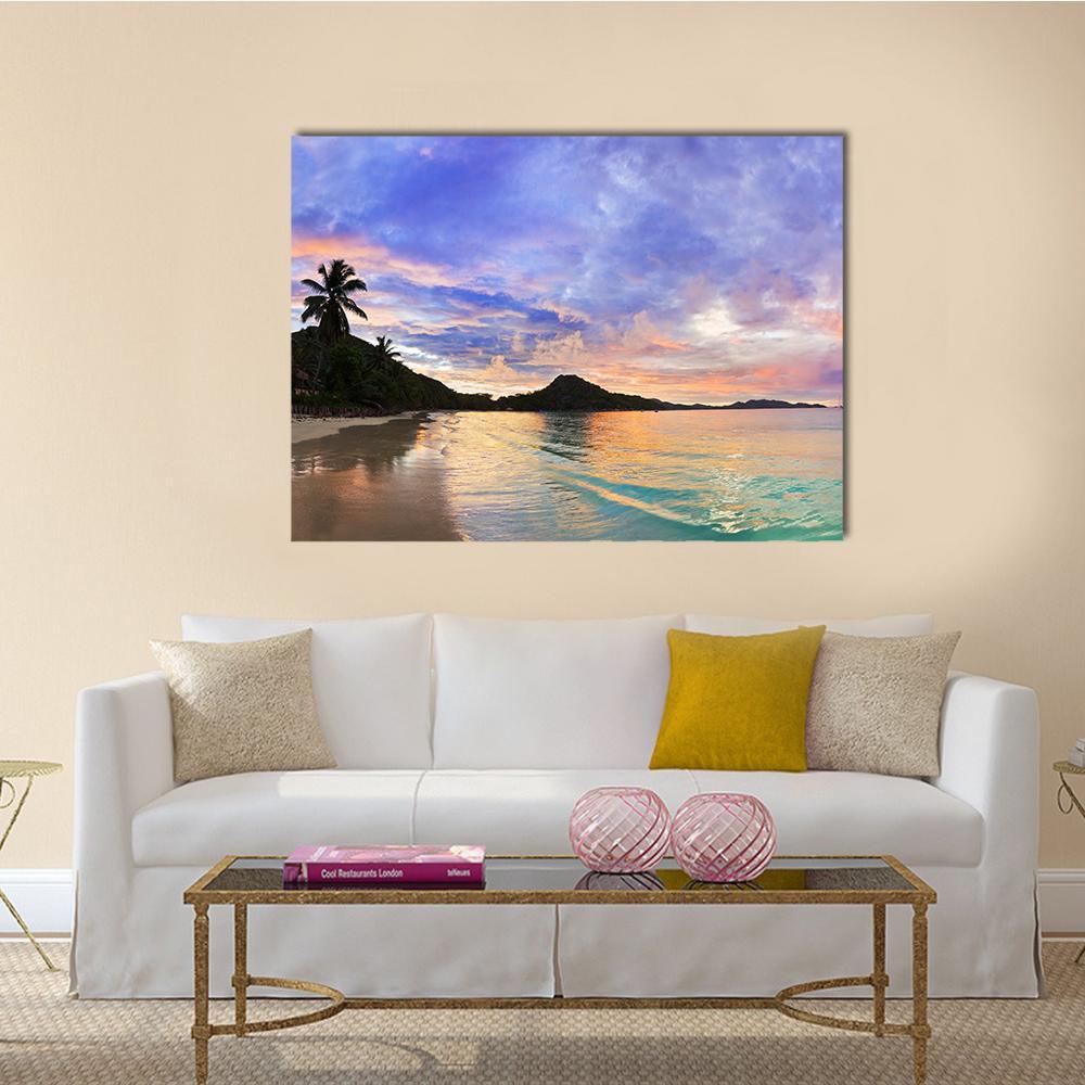 Tropical Beach Sunset with Palm Silhouette Canvas Wall Art in orange, blue and purple, single panel hung on a wall