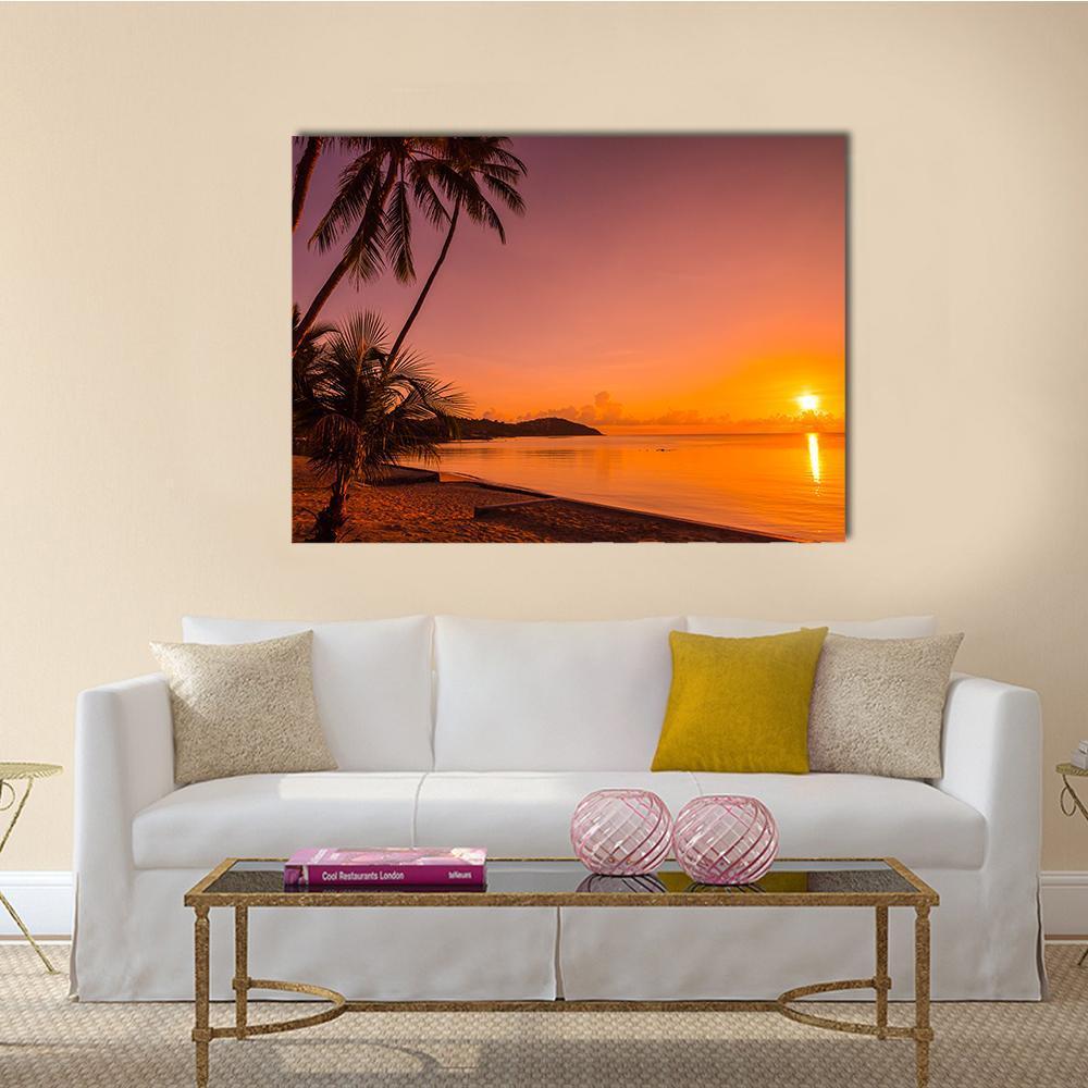 Tropical Beach Sunrise with Silhouetted Palms Canvas Wall Art in black, orange and pink, single panel hung on a wall