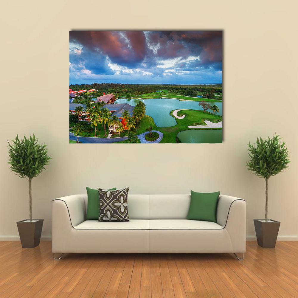 Sunset Tropical Golf Course Aerial View Canvas Wall Art in orange, green and blue, hung on a wall