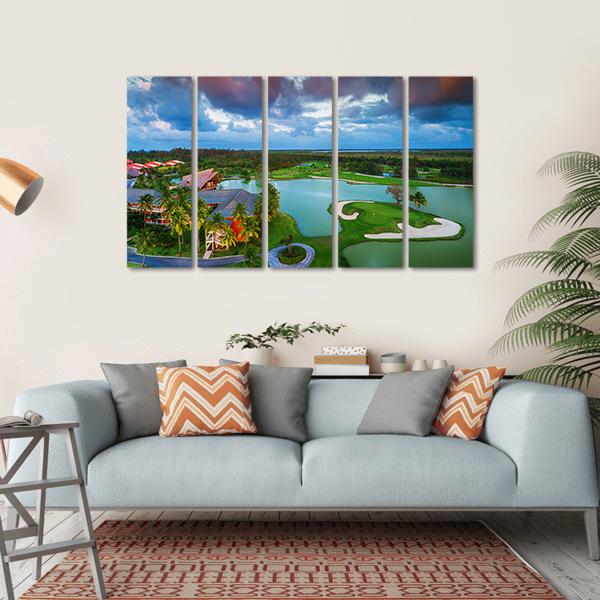 Sunset Tropical Golf Course Aerial View Canvas Wall Art in orange, green and blue, hung on a wall