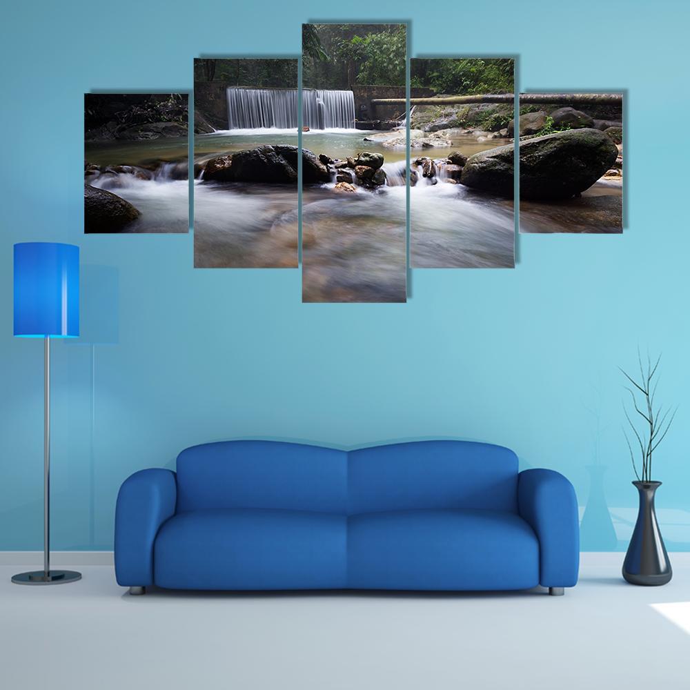Tropical Rainforest Waterfall Canvas Wall Art in gray, brown and green, 5 panel Star layout hung on a wall