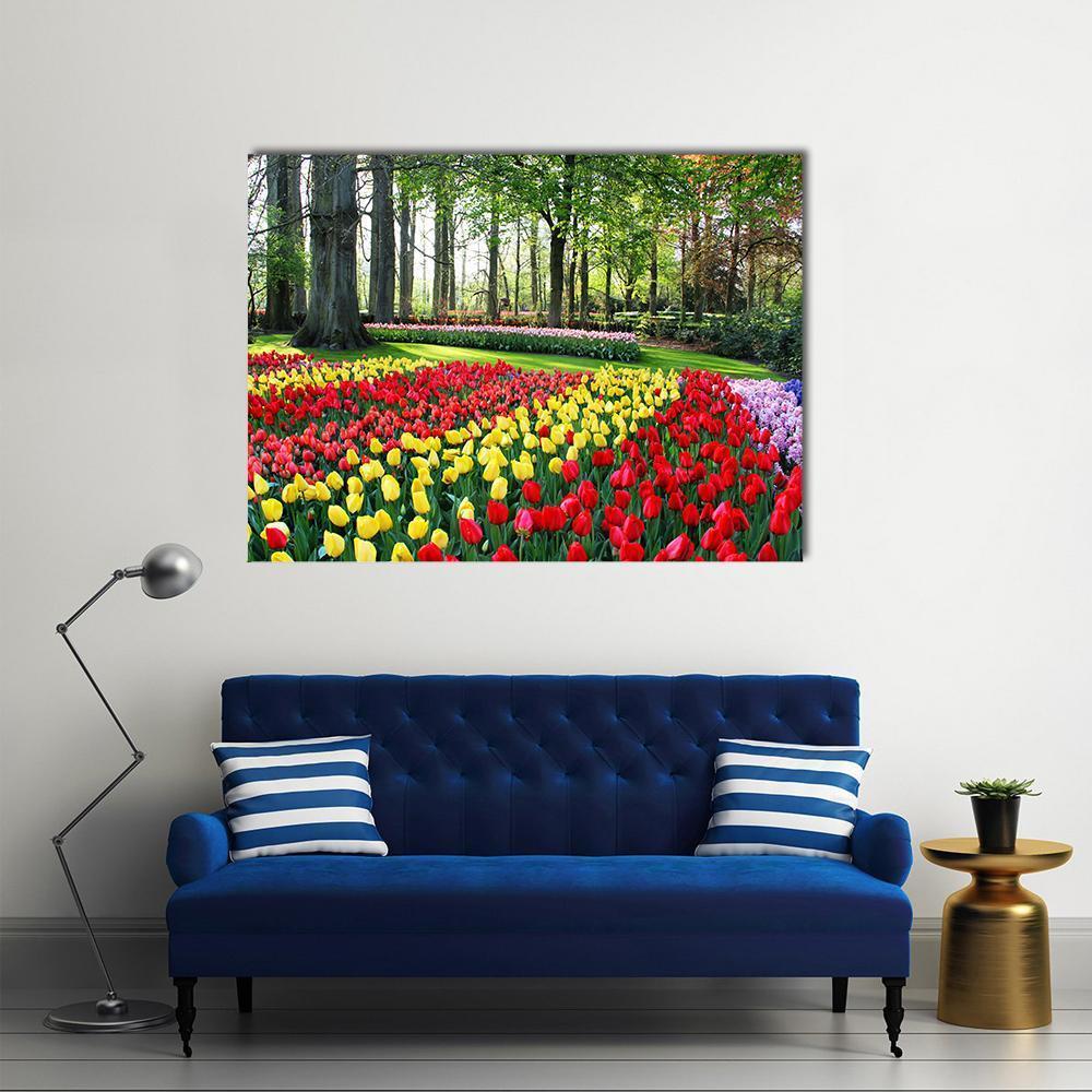 Vibrant Tulip Field in Spring Canvas Wall Art in red, yellow and green, single panel hung on a wall