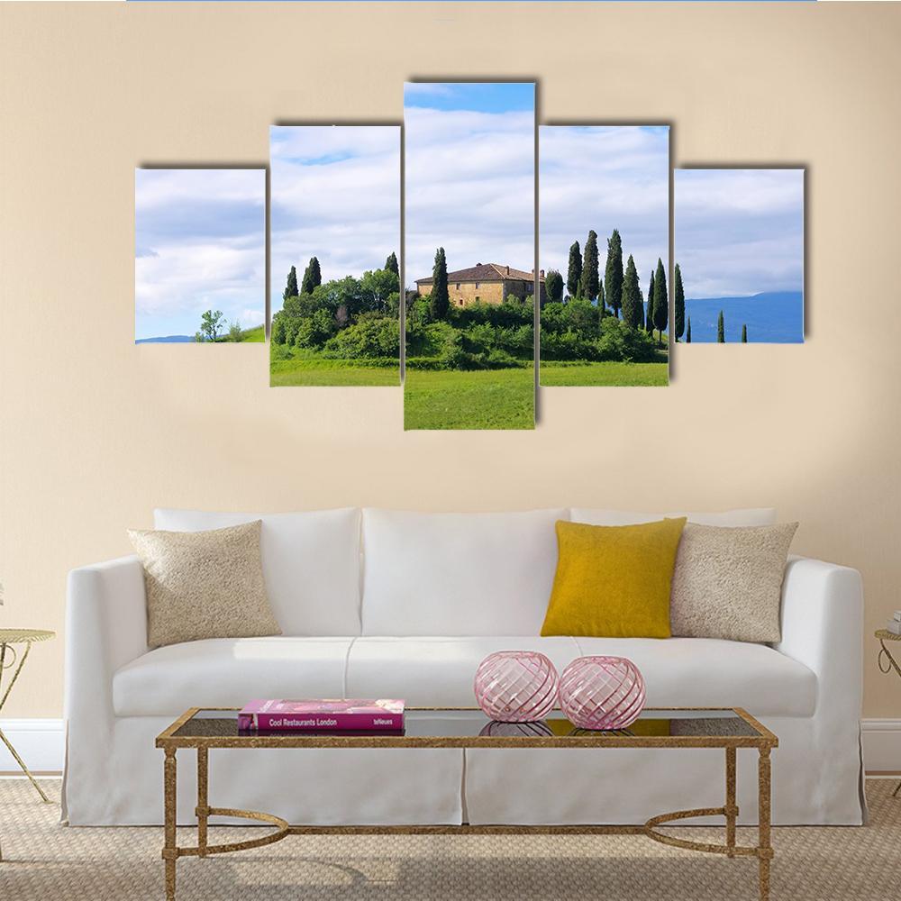 Tuscany Villa with Cypress Trees Canvas Wall Art in green and blue, 5 panel Star layout hung on a wall