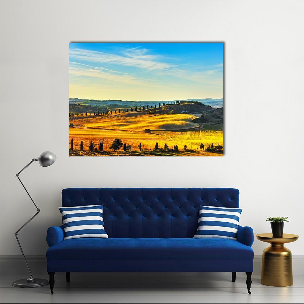 Cypress-lined Path to Hilltop Farmhouse Canvas Wall Art in yellow, green and blue, single panel hung on a wall
