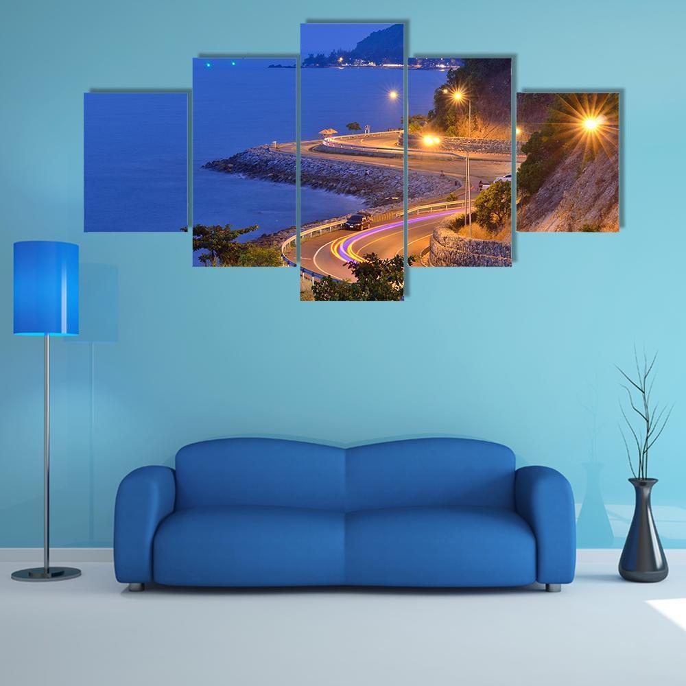 Twilight Coastal Road Beside Sea and Mountain Canvas Wall Art in yellow, blue and navy, 5 panel Star layout hung on a wall