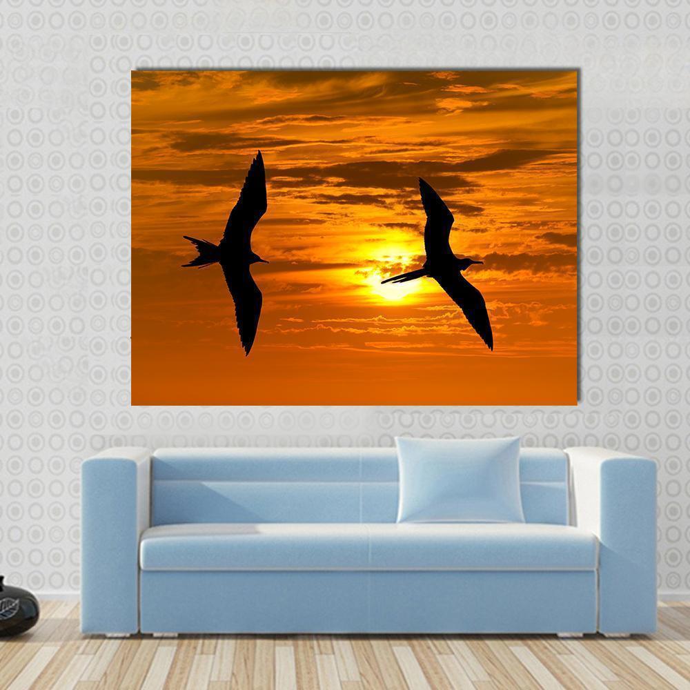 Two Birds in Silhouette at Sunset Canvas Wall Art in black, orange and yellow, single panel hung on a wall
