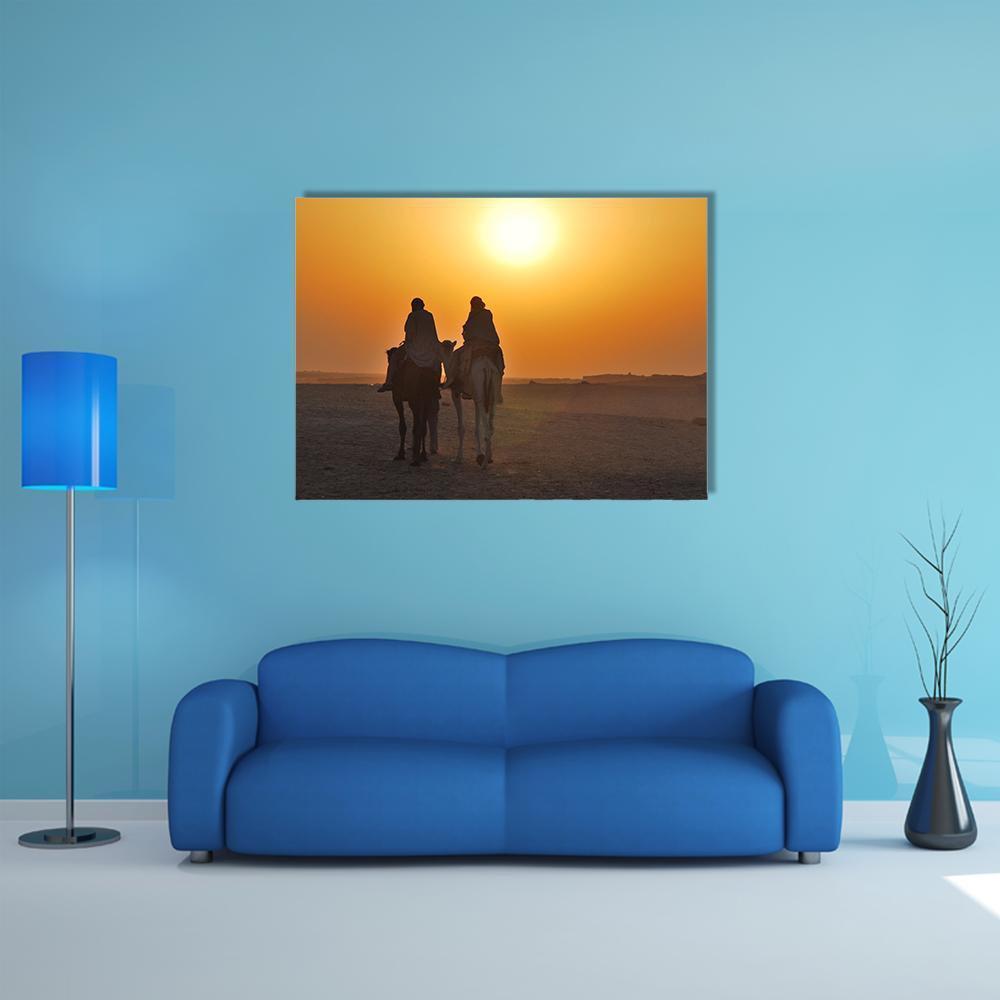 Two Camels Riding Toward the Sun Canvas Wall Art in brown, orange and yellow, single panel hung on a wall