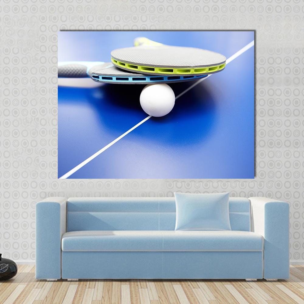 Table Tennis Rackets and Ball on Blue Table Canvas Wall Art in white, gray and blue, single panel hung on a wall